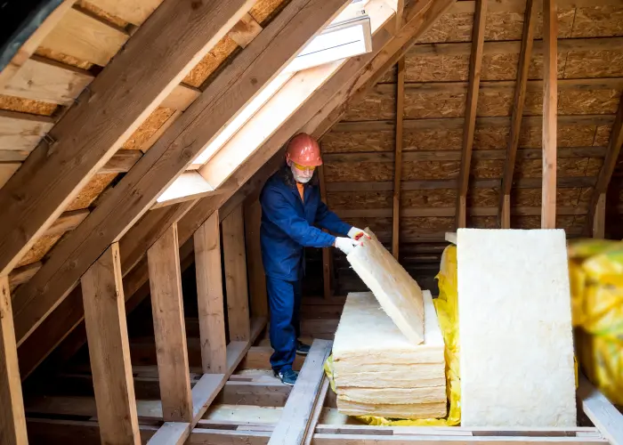 An Animal Remover technician installing attic insulation in an Indiana home after wildlife intrusion