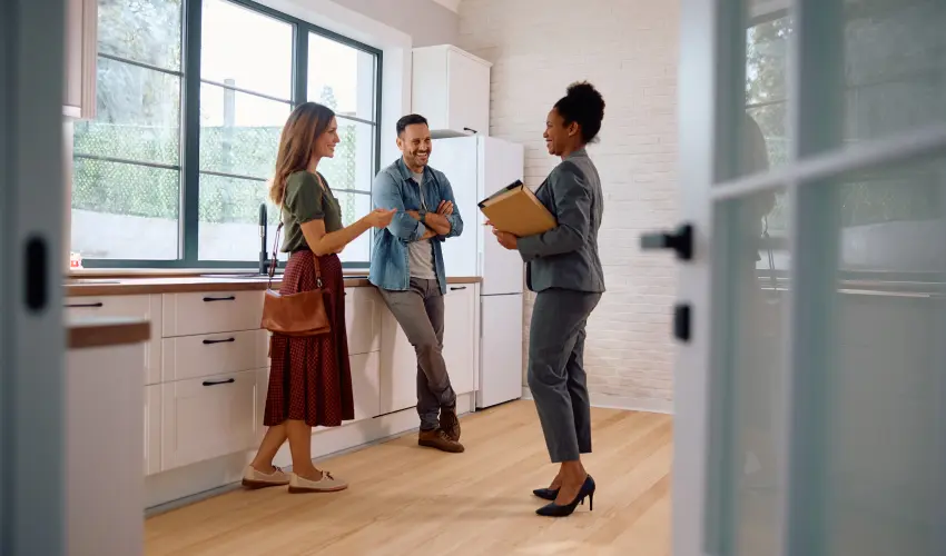Prospective homebuyers talking to a real estate agent. Before buying a home, call or contact Animal Remover for an inspection to ensure your new home is free of unwanted animal intrusions.