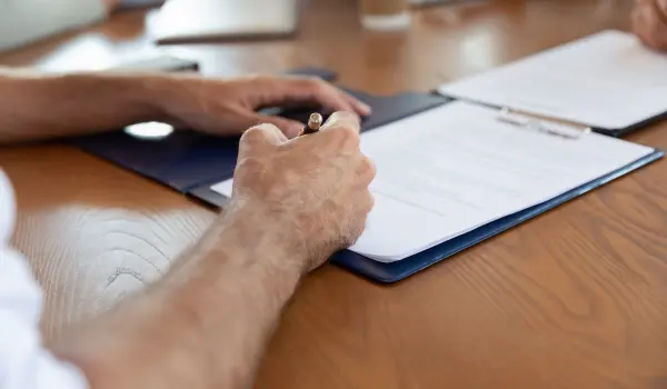 Signing a homeowners insurance contract. Wildlife removal may be covered under some insurance policies.